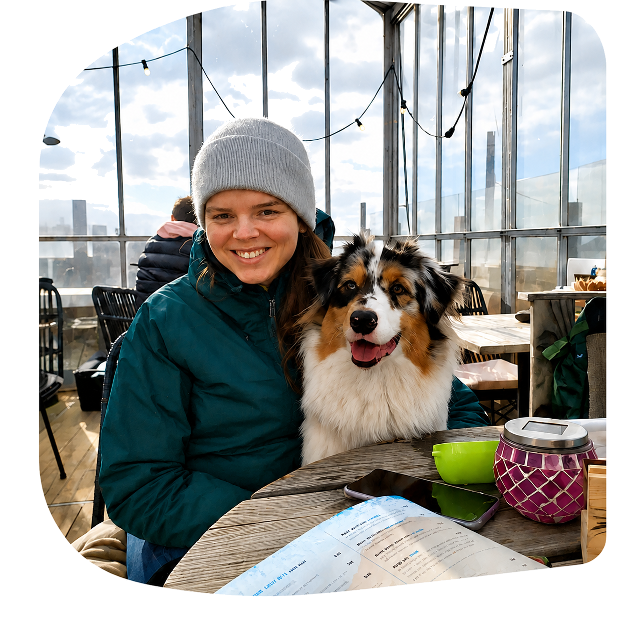Eline Nauta met haar hond Luna aan een tafel op een dakterras